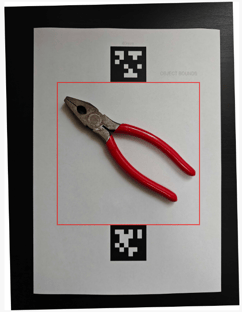 a photo of a pair of pliers with reference marks behind it